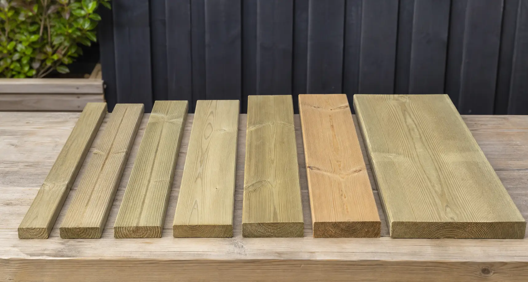 Deck boards in different widths compared with a tape measure and planning sheet